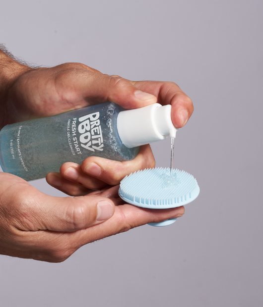 Putting facial cleanser on exfoliating scrubber