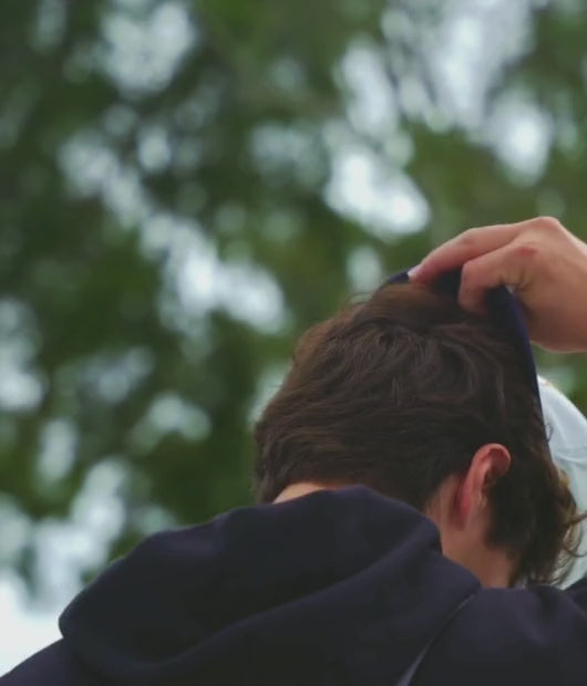 Man putting No Bad Days hat in nice park